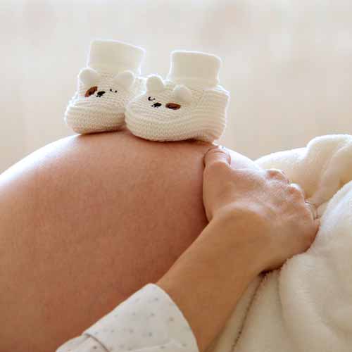 Chaussons enfant sur ventre femme enceinte